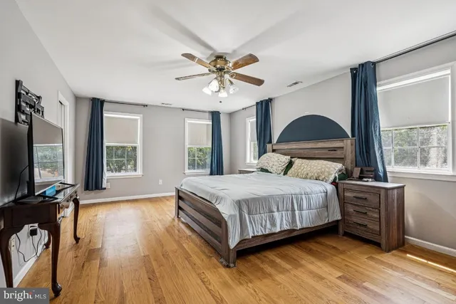 a bedroom with a bed and a flat tv screen on dresser