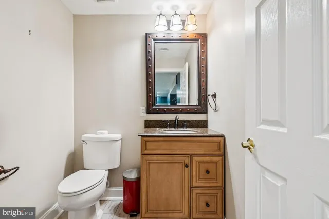 a bathroom with a toilet a sink and mirror