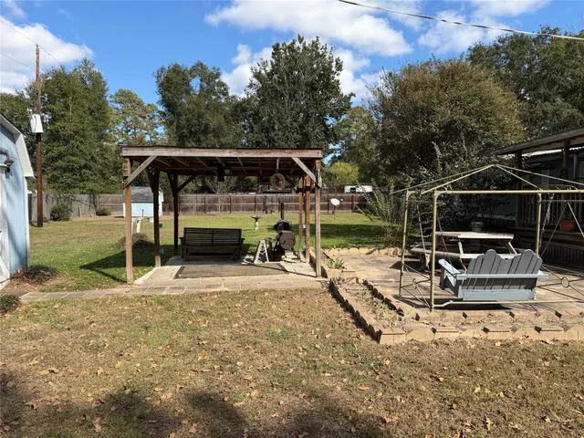 a view of a swimming pool with a yard and large trees