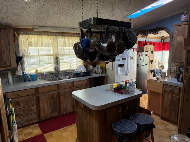 a kitchen with stainless steel appliances granite countertop a sink and a refrigerator