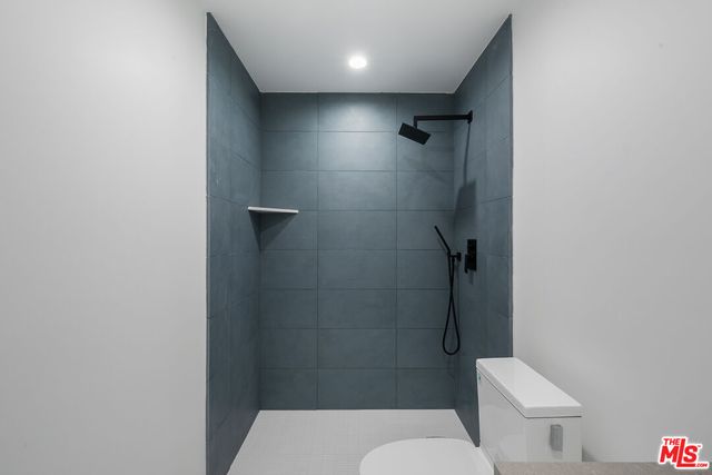 a white toilet sitting next to a bathroom sink and vanity