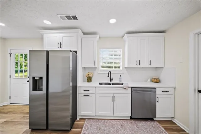 a kitchen with a refrigerator sink and cabinets