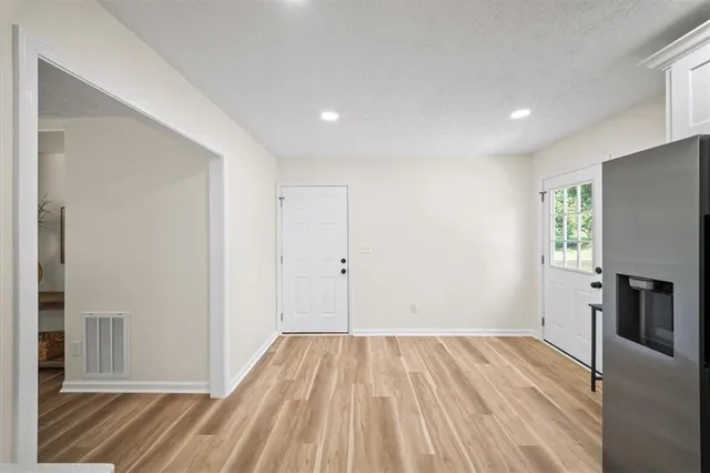 a view of a room with wooden floor a ceiling fan and a window