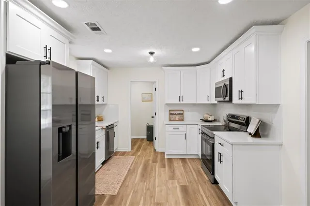 a kitchen with stainless steel appliances a refrigerator stove and sink