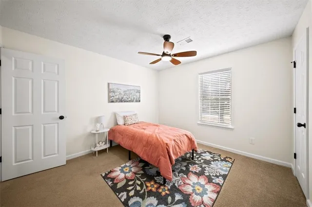 a bed sitting in a bedroom next to a window