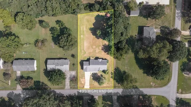 an aerial view of a residential apartment building with a yard and garden space