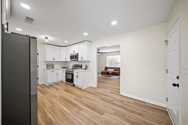 a kitchen with a refrigerator and a stove top oven