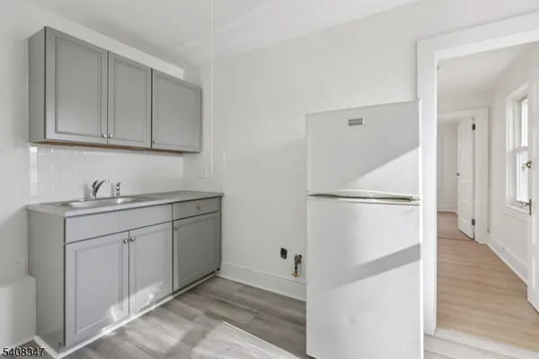 a kitchen with white cabinets and white appliances