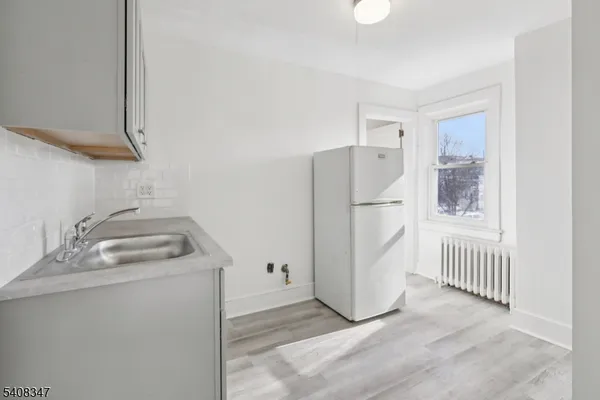 a kitchen with a refrigerator sink and cabinets