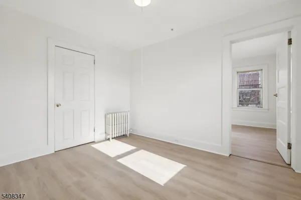 an empty room with cabinet and windows