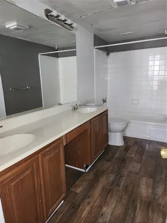 a bathroom with a sink a toilet a mirror and shower