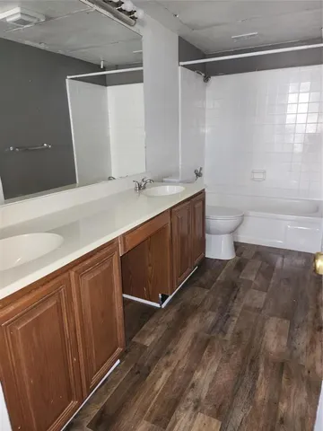 a spacious bathroom with a double vanity sink toilet and a tub