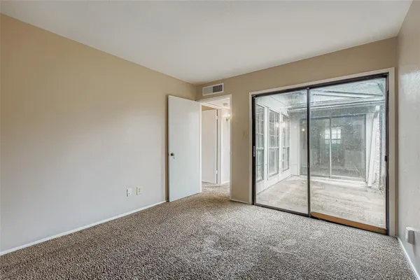 an empty room with sliding glass door and shower