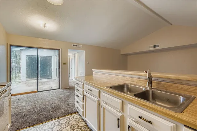 a kitchen with a sink and large mirror