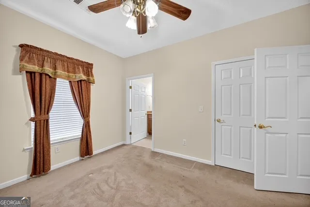 an empty room with stairs and a chandelier fan