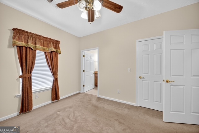 611 Moncrief Road Roberta, GA 31078 - Photo 18 of 30 an empty room with stairs and a chandelier fan
