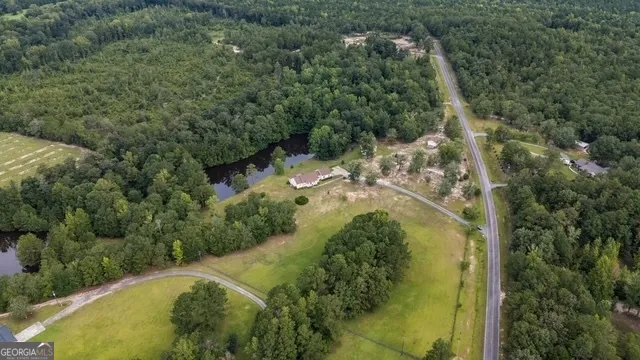 an aerial view of lake residential house with outdoor space and trees all around
