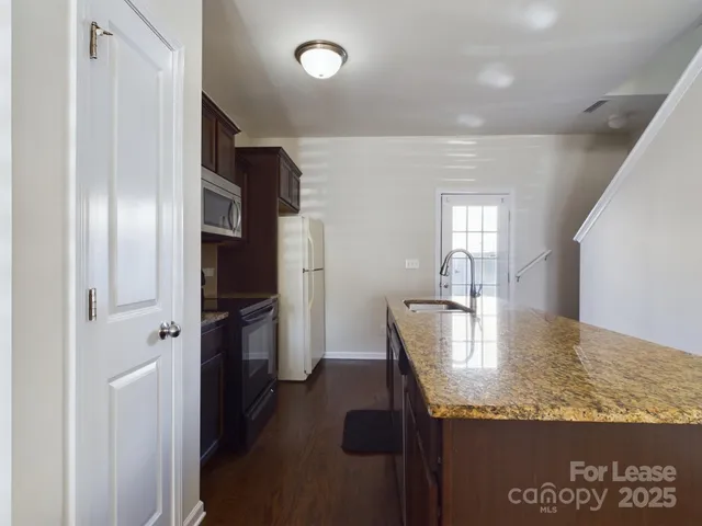 a kitchen with stainless steel appliances granite countertop a refrigerator and a sink