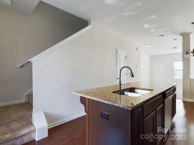 a kitchen with granite countertop a sink and a stove