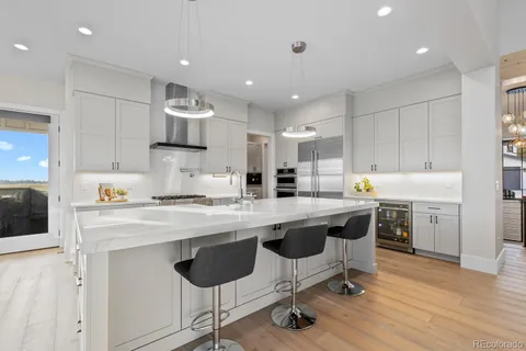 a large kitchen with stainless steel appliances lots of counter space and wooden floor
