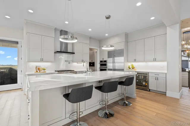a large kitchen with stainless steel appliances lots of counter space and wooden floor
