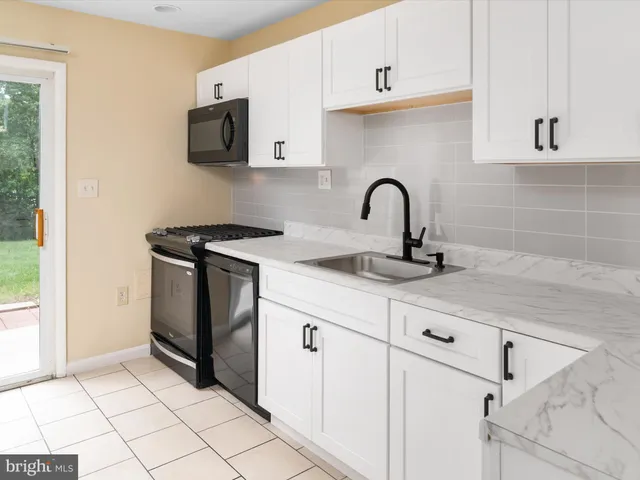 a kitchen with stainless steel appliances granite countertop a sink and a stove