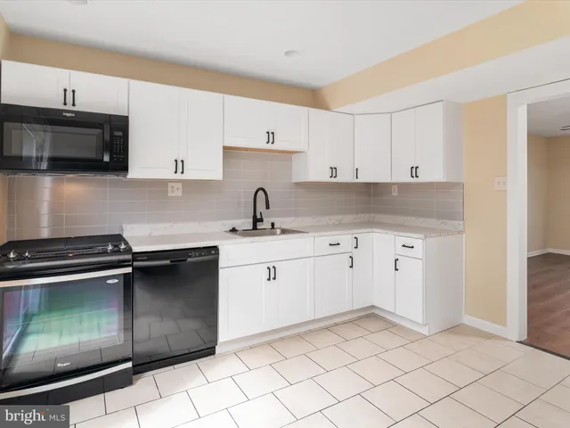 a kitchen with granite countertop a stove sink and cabinets