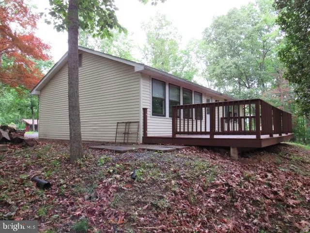 a backyard of a house with wooden deck and barbeque oven