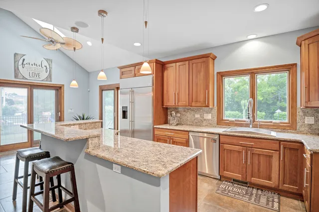 a kitchen with stainless steel appliances granite countertop a sink and a refrigerator