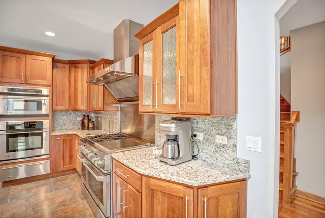 a view of an empty room with wooden floor and windows