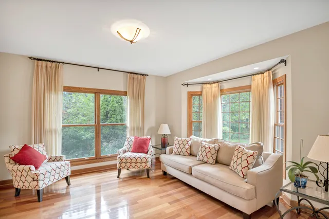 a living room with furniture flowerpot and wooden floor