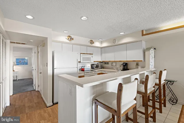 a kitchen with cabinets and chairs