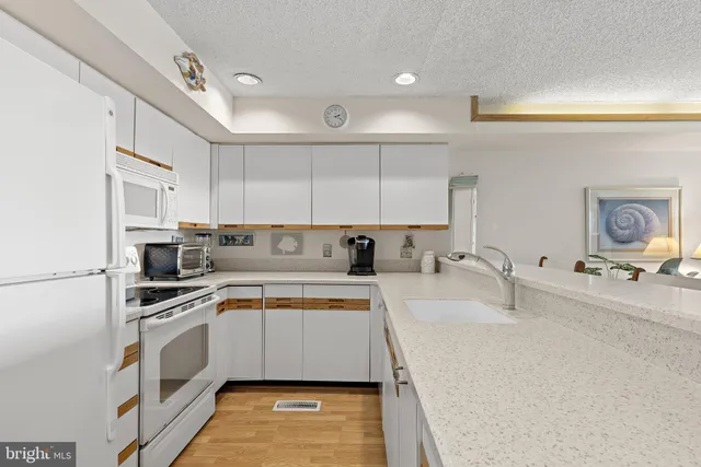 a kitchen with a sink white cabinets and stainless steel appliances