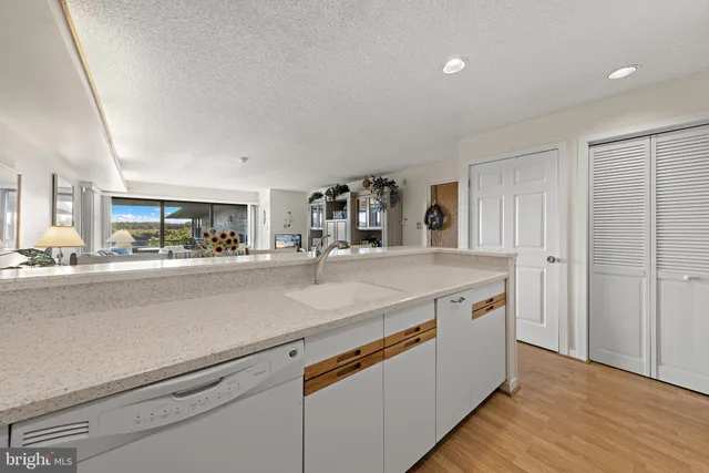 a view living room with stainless steel appliances granite countertop a sink and a refrigerator