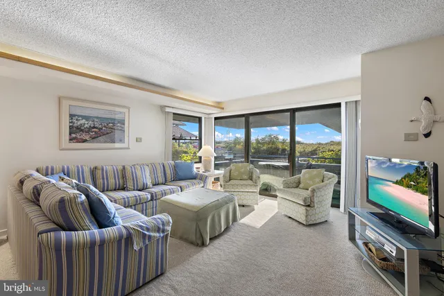 a living room with furniture large window and flat screen tv