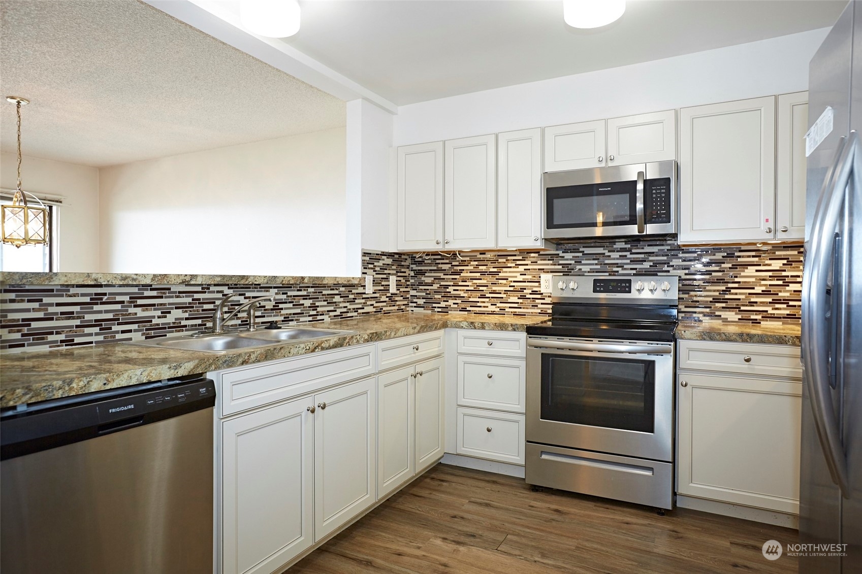 6902 Southeast Riverside Drive, Unit 4 Vancouver, WA 98664 - Photo 13 of 25 a kitchen with granite countertop white cabinets stainless steel appliances and a counter space