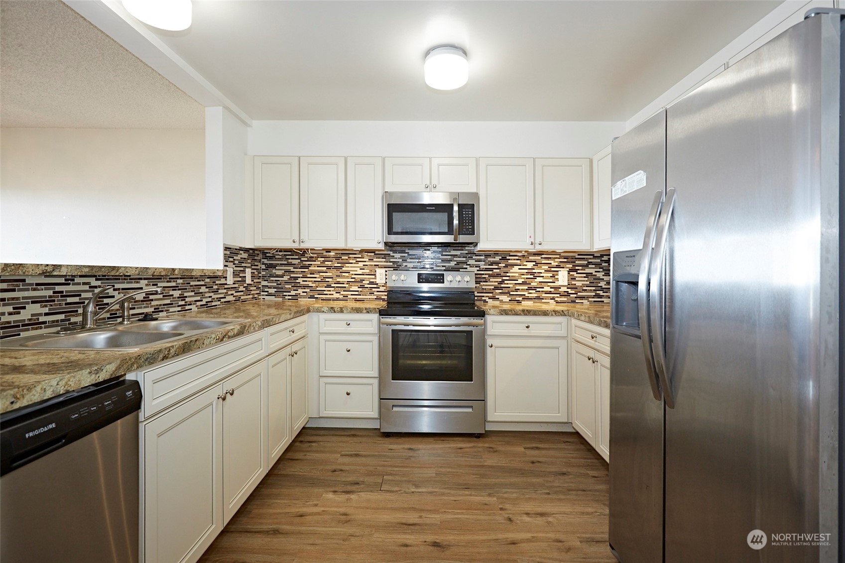 6902 Southeast Riverside Drive, Unit 4 Vancouver, WA 98664 - Photo 14 of 25 a kitchen with stainless steel appliances granite countertop a stove a refrigerator and a microwave