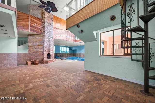 an empty room with a window and a fan