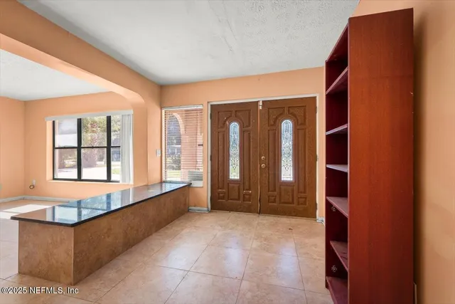 a view of an empty room with a ceiling fan and a window
