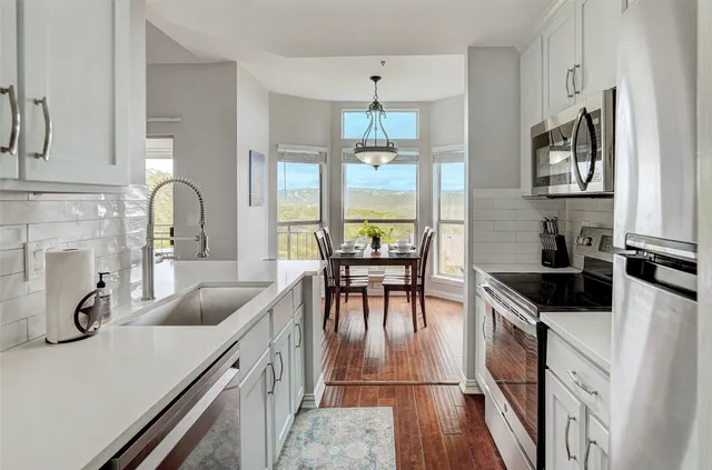 a kitchen with granite countertop a sink and white cabinets