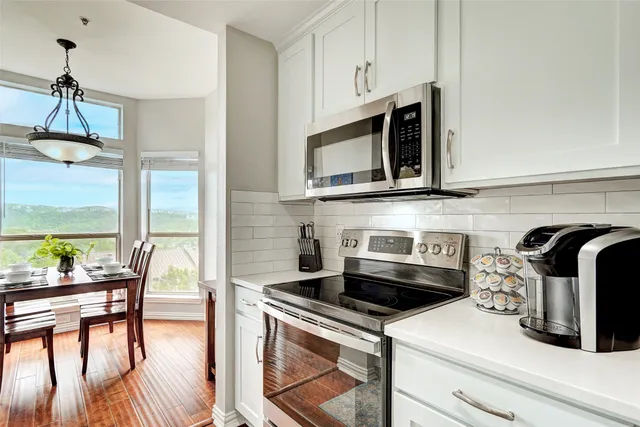 a kitchen with granite countertop a table chairs stove and cabinets
