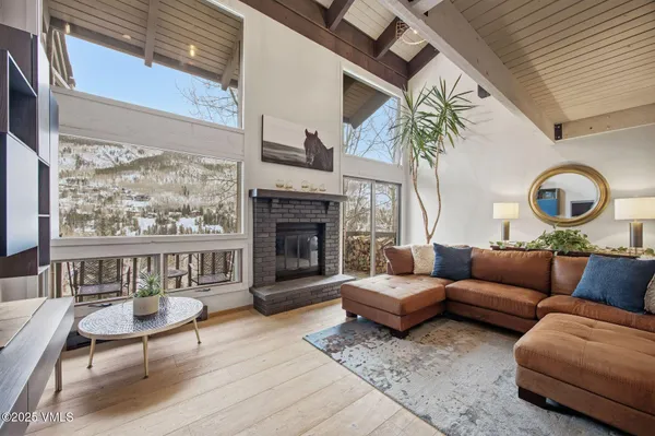 a living room with furniture a fireplace and a large window