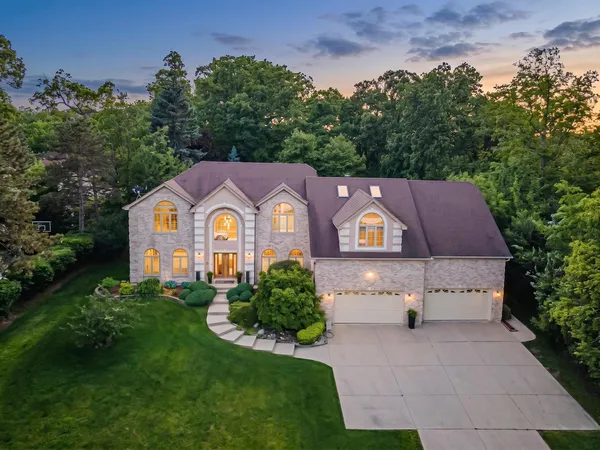 a aerial view of a house with a yard and large trees