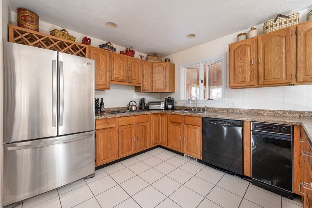 4 Camelot Circle Dudley, MA 01571 - Photo 15 of 42 a kitchen with granite countertop stainless steel appliances a refrigerator a sink and cabinets