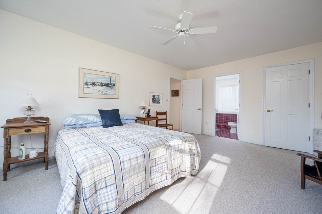 4 Camelot Circle Dudley, MA 01571 - Photo 30 of 42 a spacious bedroom with a bed a couch and a chandelier