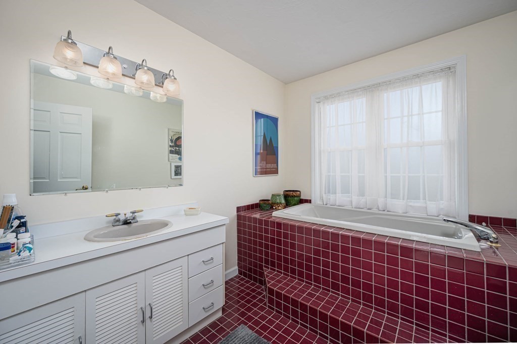 4 Camelot Circle Dudley, MA 01571 - Photo 32 of 42 a bathroom with a double vanity sink a mirror and a bathtub