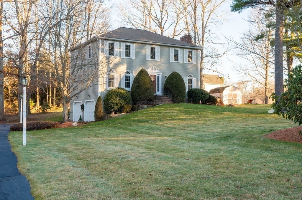 4 Camelot Circle Dudley, MA 01571 - Photo 5 of 42 a front view of a house with a garden and trees