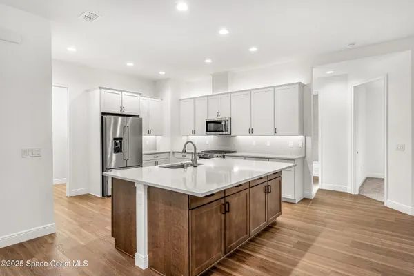 a kitchen with kitchen island a sink stove and refrigerator