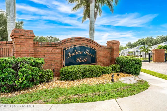 a front view of a house with a garden and trees
