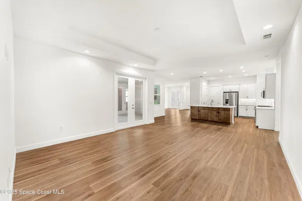 a view of a kitchen with wooden floor and a window